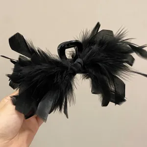 Detail view of large black ostrich feather shark clip for hair styling