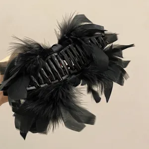 Detailed macro view showing the soft texture of black ostrich feathers on a large hair claw clip