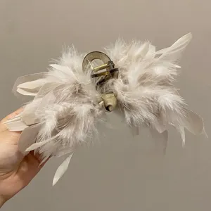 Detailed macro shot showing textures of elegant ostrich feather hair claw clip in beige