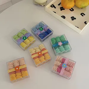 Set de pequeñas gomas elásticas de colores en cajas de almacenamiento cuadradas transparentes