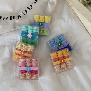 Vista detallada de mini gomas de pelo de colores en cajas de almacenamiento transparentes