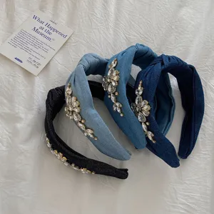 Detailed macro view of luxury rhinestone patterns on denim headbands.