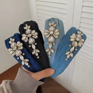 Close-up of four rhinestone embellished denim headbands in assorted blue shades.