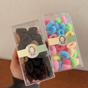 Set of colorful and brown mini soft hair elastics for baby girls in clear plastic boxes