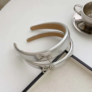 Elegant silver metallic PU leather headband featuring a delicate crystal bow decoration