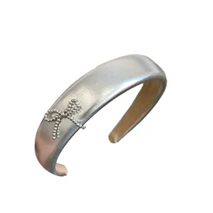 Stylish silver PU leather padded headband with metallic finish and beaded bow detail