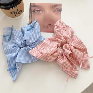 Gingham bow scrunchie with elegant ribbons in blue and pink pastel colors for women
