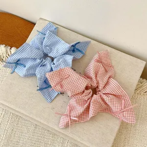 Elegant Korean style gingham scrunchies with delicate bow ribbons in blue and pink.