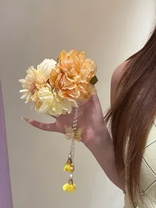 Close-up detail of a bright yellow floral hair clip featuring a golden butterfly and pearl tassel.