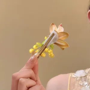 Back view detail of yellow orchid flower hair clip with golden alligator metal fastener