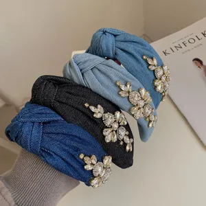 Close-up of four denim knotted headbands with heavy rhinestone flower decorations
