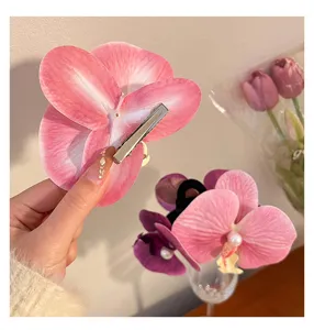 Detailed macro view showing the metal clip and petal texture of the pink orchid hair clip