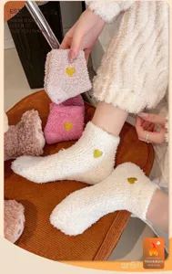 Nahaufnahme flauschiger Korallenvlies-Socken mit gelber Herz-Stickerei für Damen im Winter