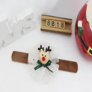 Vista detallada de pulsera de Navidad con reno de peluche, tul blanco y lazo verde.