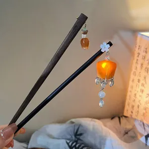 Close-up of elegant Chinese style hairpins featuring orange lantern tassel charms