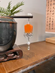 Detail of a vintage Chinese wood hairpin with orange lantern tassel and crystal beads