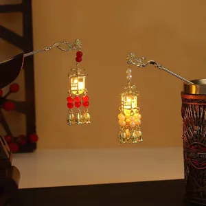 Detail view of glowing Chinese lantern hairpins with delicate tassels and warm light effects