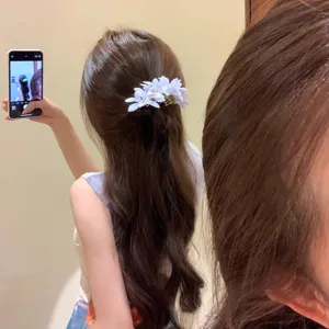 Dettaglio di un fermaglio per capelli con fiori viola in un'acconciatura elegante