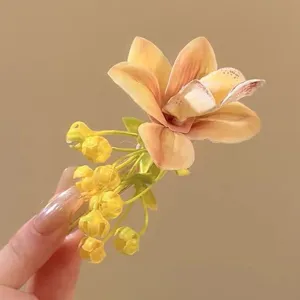 Bright yellow flower hair clip with realistic orchid petals for vacation style