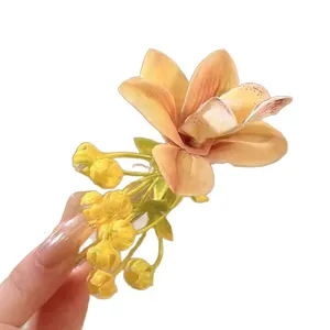 Elegant bright yellow orchid flower hair clip perfect for spring vacation hairstyles