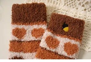 Detailtextur warmer Korallenfleece-Socken mit braunem Herzmuster und Eichelbestickung