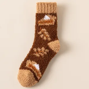Detailaufnahme dicker Korallenfleece-Socken mit herbstlichen Blatt- und Kuchenmustern