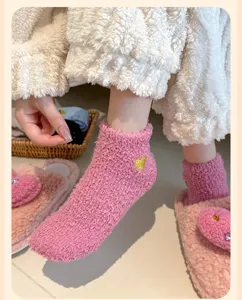 Detailansicht rosa Korallenvlies Socken mit kleinem besticktem goldenem Herzmuster