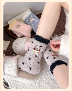 Nahaufnahme von flauschigen Korallenvlies-Socken mit süßem Bären und Schleife