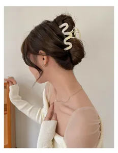 Eleganter gewellter weißer Haargreifer präsentiert an einer edlen Dutt-Frisur für Damen