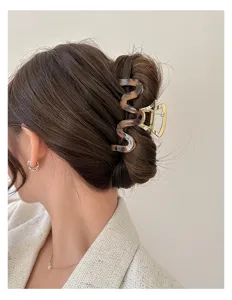 Nahaufnahme einer gewellten Haarspange mit Schildpattmuster in einer Hochsteckfrisur.