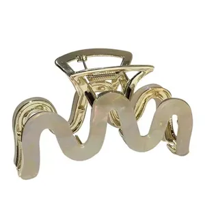 Goldene gewellte Haarklammer mit schillerndem Muschelmuster für elegantes Haarstyling