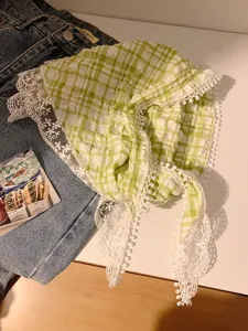 Detalle del pañuelo de cuadros verdes estilo pastoral con un elegante ribete de encaje