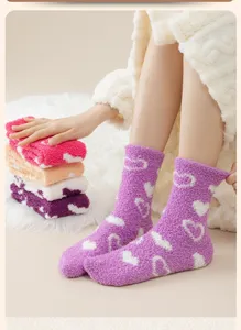 Detail von gemütlichen lila Korallenfleece-Socken mit weißen Herzmustern und weicher Textur.