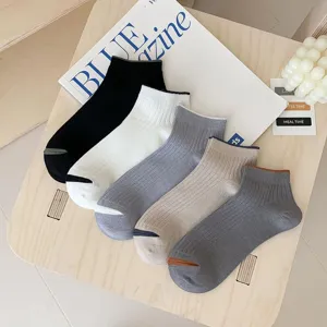 Detail view of five pairs of men's ribbed low-cut boat socks in neutral colors