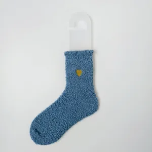 Nahaufnahme der gemütlichen blauen Korallenfleece-Wintersocke mit kleiner goldener Herzstickerei.