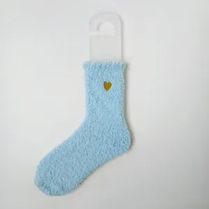 Detailansicht einer weichen hellblauen Korallenvlies-Socke mit goldener Herzstickerei