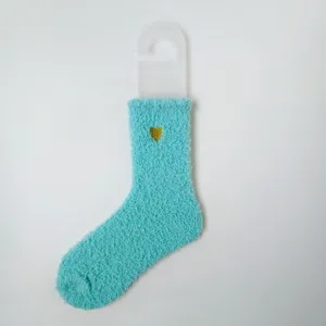 Detaillierte Nahaufnahme weicher türkisfarbener Korallenfleece-Socken mit Herz-Stickerei