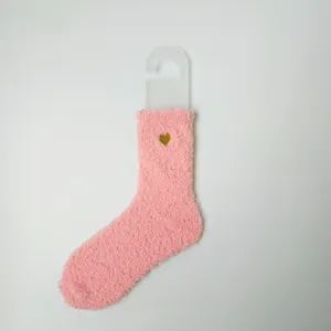 Detailansicht der weichen rosa Korallenvlies-Textur und der goldenen Herzstickerei.