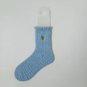 Detailaufnahme einer hellblauen Korallenvlies-Socke mit goldener Herz-Stickerei