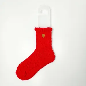 Detailansicht der roten flauschigen Korallenvlies-Socke mit kleiner Goldherz-Stickerei