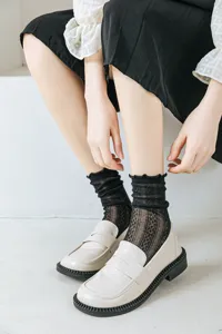 Dettaglio calzini neri a balze in rete con motivo a rombi in stile college JK Lolita per donna