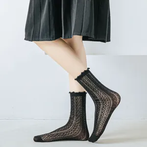 Dettaglio calzini a rete neri stile JK con bordo in pizzo e raffinati motivi vintage