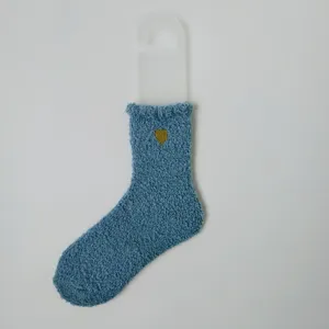 Detailansicht einer weichen blauen Korallenvliessocke mit goldener Herzbestickung