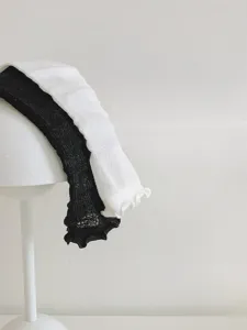 Dettaglio di calzini con volant bianchi e neri con delicati bordi in pizzo stile JK.