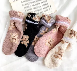 Detailaufnahme von weichen Korallenvlies-Wintersocken mit Bärenmuster und Rüschenspitze