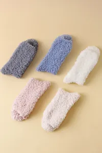 Draufsicht auf fünf weiche Korallenvlies-Socken in Pastelltönen für den Winter