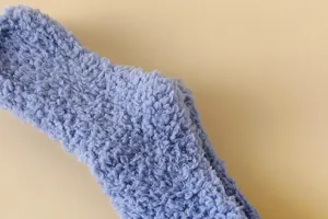 Hochauflösendes Makro-Detail der weichen lila Korallenfleece-Textur auf einer dicken Wintersocke