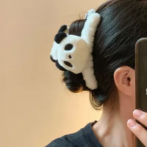 Vue détaillée d'une jolie pince à cheveux en peluche panda sur un chignon.