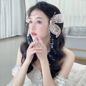 Détail d'une pince à cheveux ailes de papillon en cristal avec pompons perlés