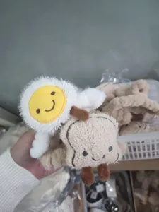Détail de pinces à cheveux en peluche avec motifs œuf au plat et pain grillé